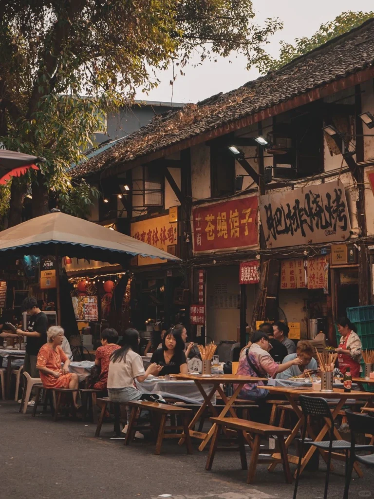 Locals dining at a traditional Chengdu street side eatery with vintage style signs and wooden furniture