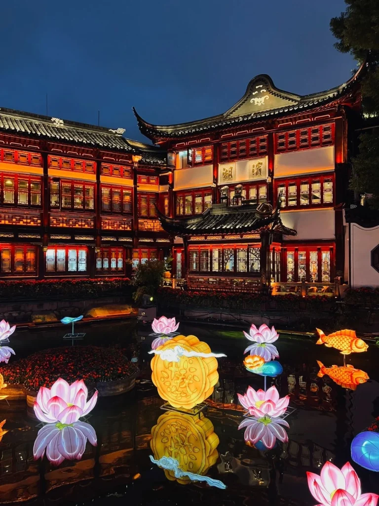 Brightly illuminated floating lotus flowers and mooncake lanterns on the water during a Mid Autumn Festival in Shanghai