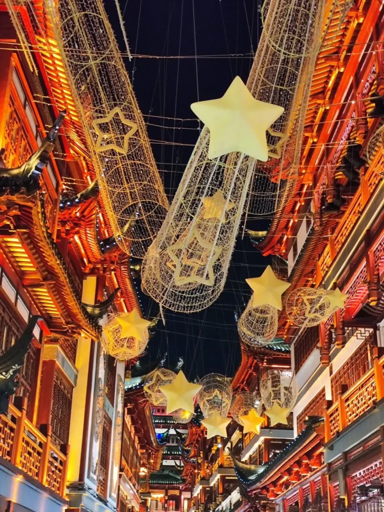 Illuminated star shaped decorations hanging over traditional Chinese street during Mid Autumn Festival night in Yuyuan Garden Shanghai