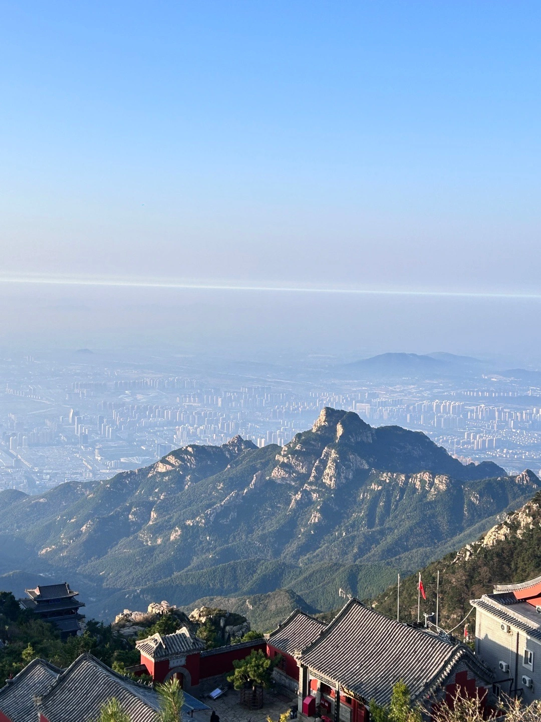View from Mount Tai overlooking the city below under a clear blue sky