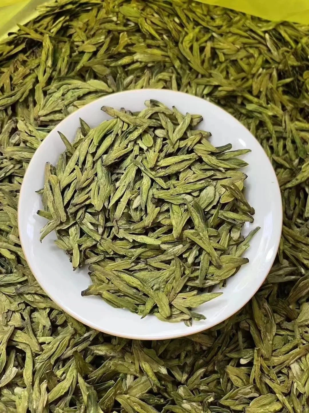 A cup of freshly brewed West Lake Longjing tea with vibrant green tea leaves floating