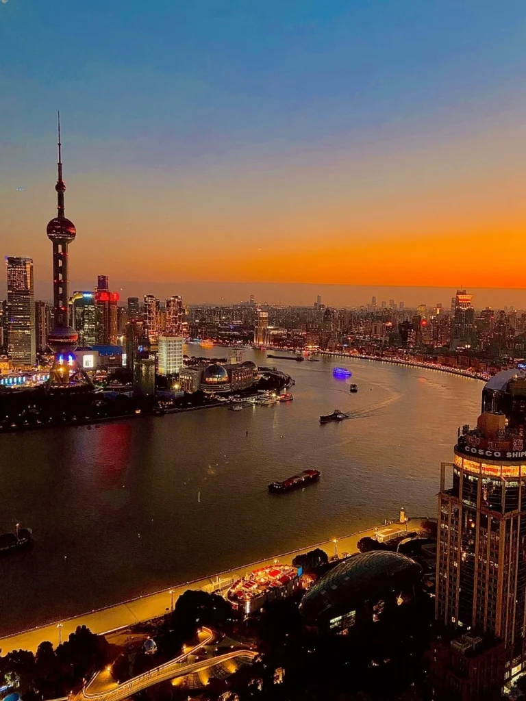 A stunning sunset view of Shanghais Oriental Pearl Tower and Huangpu River capturing the vibrant colors of the skyline