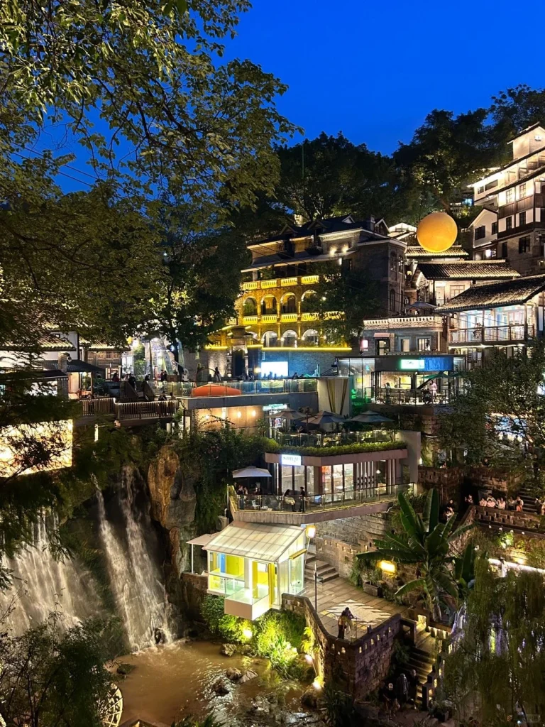 Chongqing scenic night view with a cascading waterfall and illuminated traditional buildings