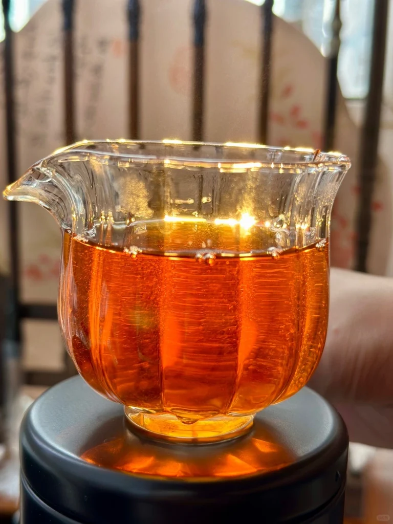Close up of vibrant amber colored Keemun black tea in a glass teapot