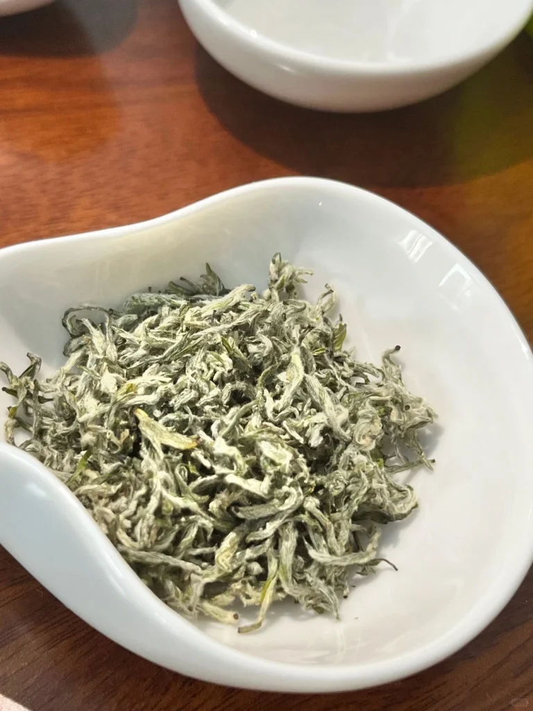 Dried Duyun Maojian tea leaves presented in a porcelain bowl emphasizing their elegant and fine texture