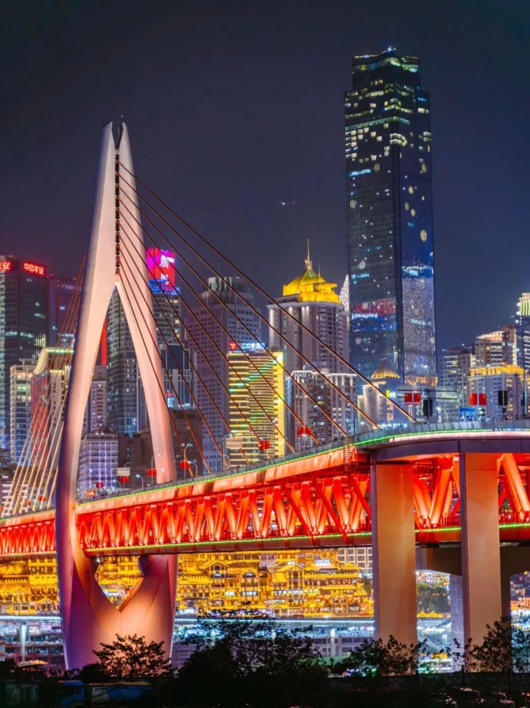 Night view of Chongqings Hongya Cave and illuminated red bridge against the city skyline