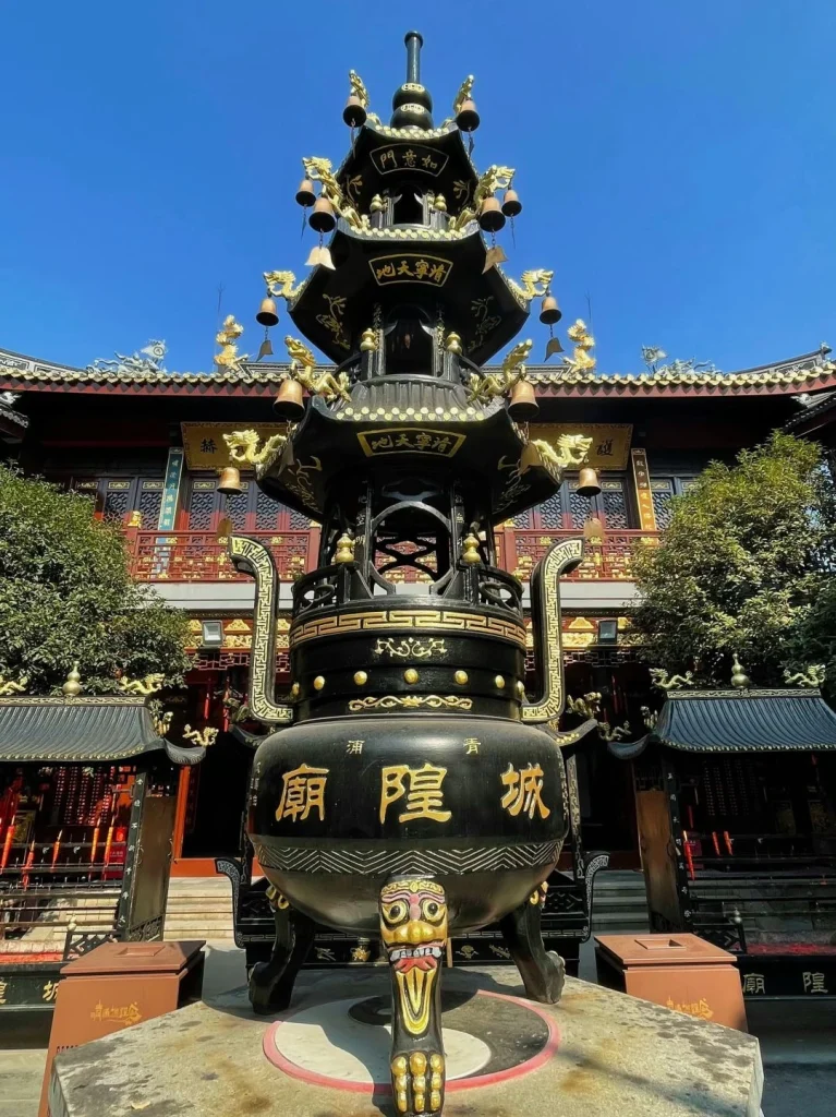 Ornate incense burner in front of Chenghuang Temple adorned with golden dragons and traditional motifs in Shanghai