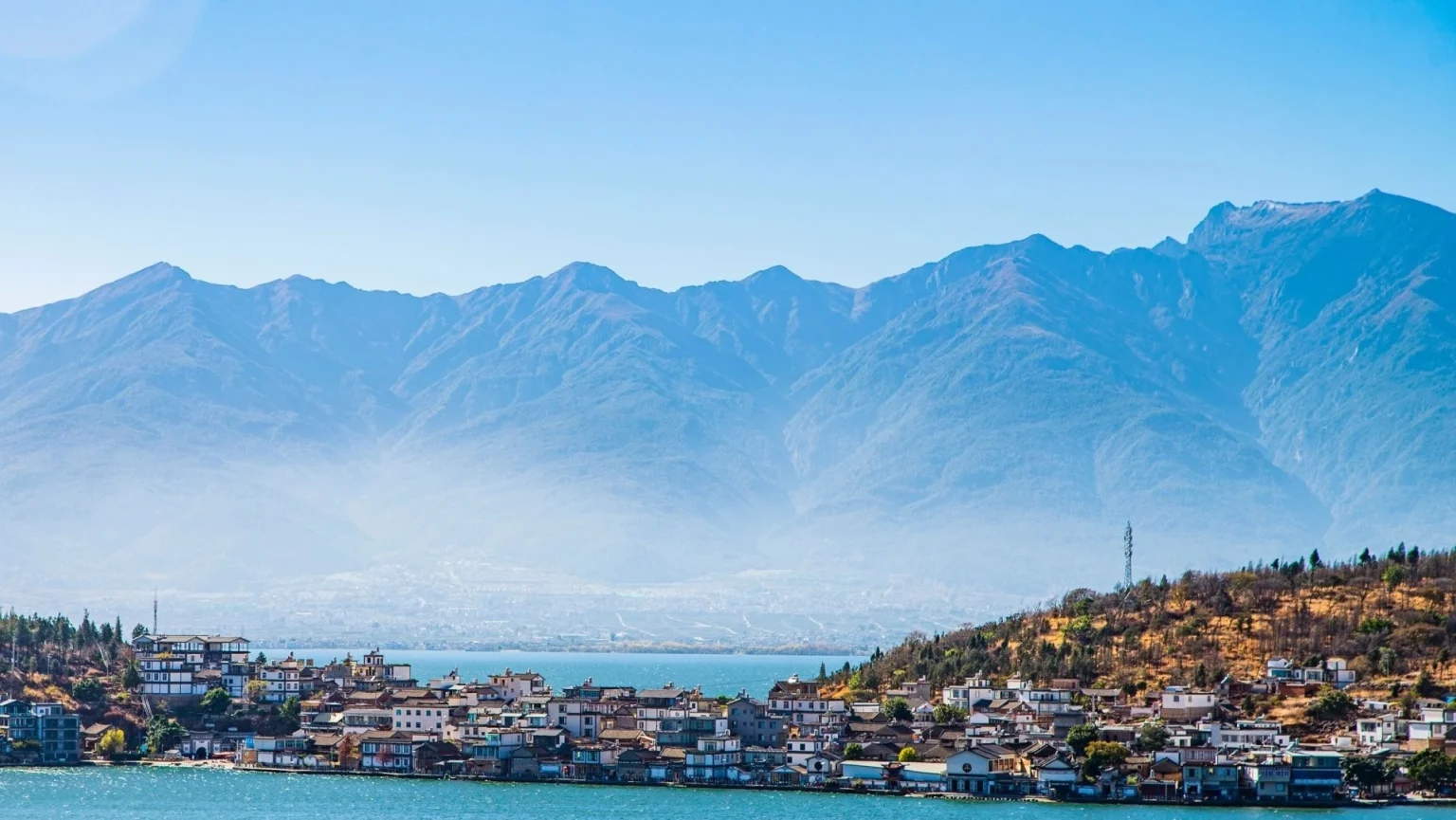 Panoramic view of a lakeside village surrounded by lush hills and majestic mountains under a clear blue sky in Dali China - Dali, Stunning Scenery and Rich Culture Agustus 2026 - The China Journey - Chinese - The China Journey Panoramic view of a lakeside village surrounded by lush hills and majestic mountains under a clear blue sky in Dali China - Dali, Stunning Scenery and Rich Culture Agustus 2026 - The China Journey - Chinese - The China Journey