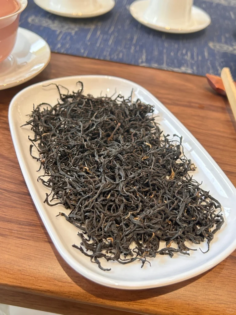 Premium loose leaf Keemun black tea arranged on a white ceramic plate