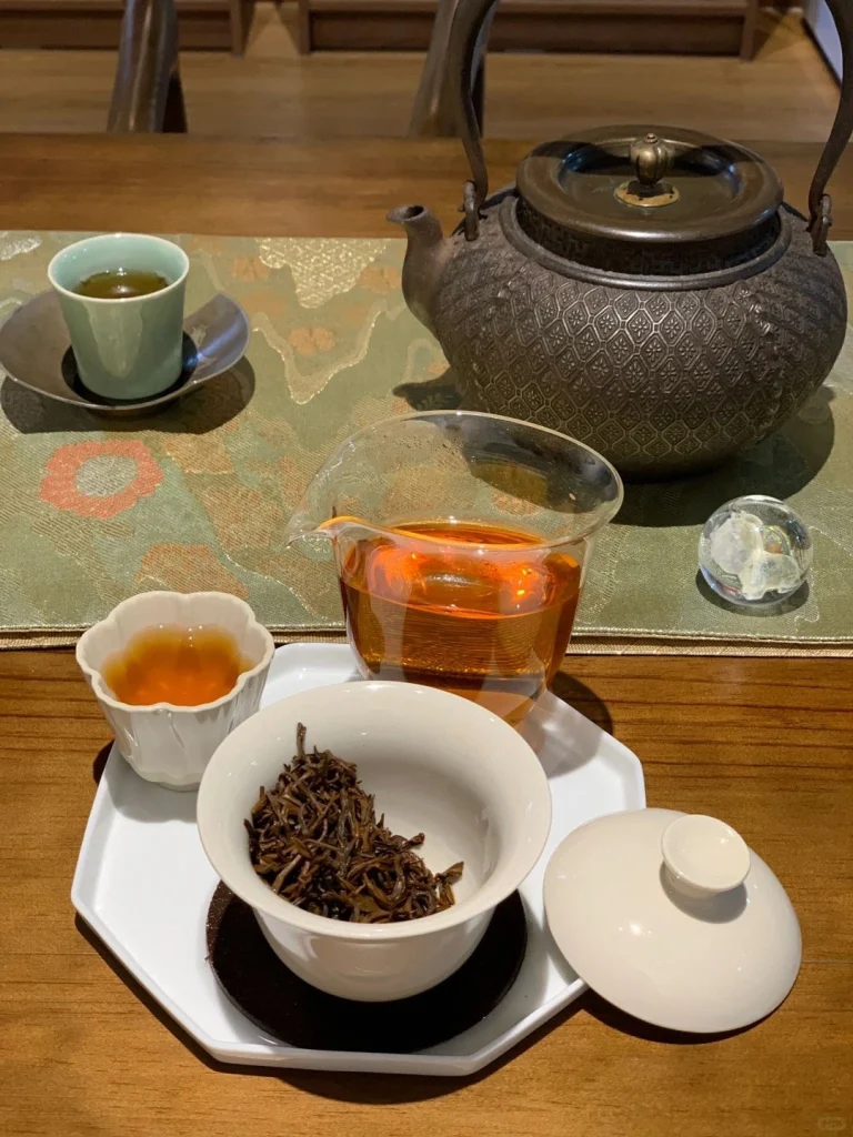 Traditional Keemun black tea brewing setup with teapot and tea cups on a wooden table