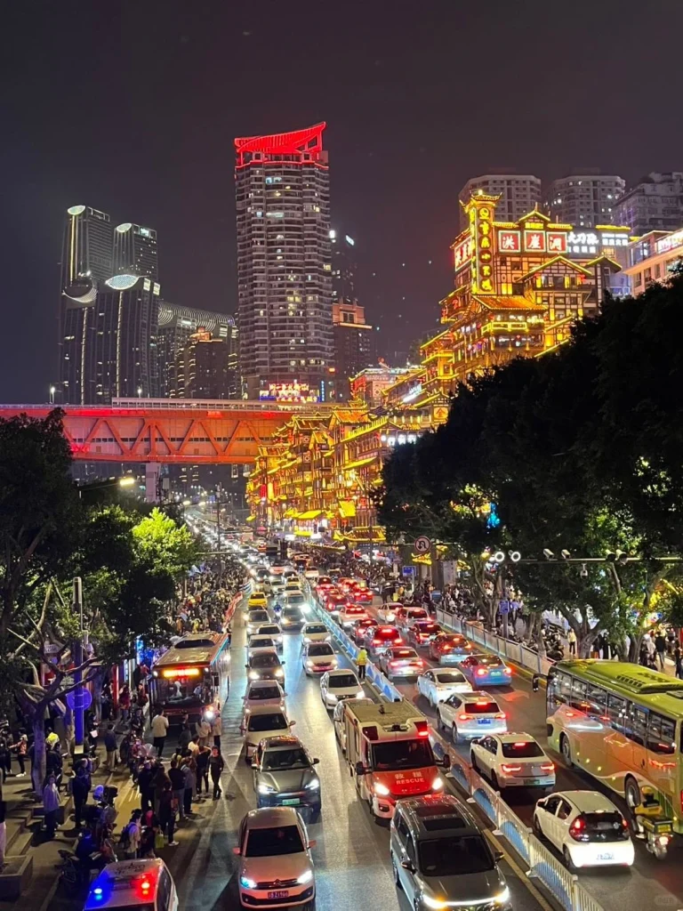 Vibrant night view of Chongqing with illuminated Hongya Cave bustling traffic and modern skyscrapers showcasing the citys dynamic urban atmosphere