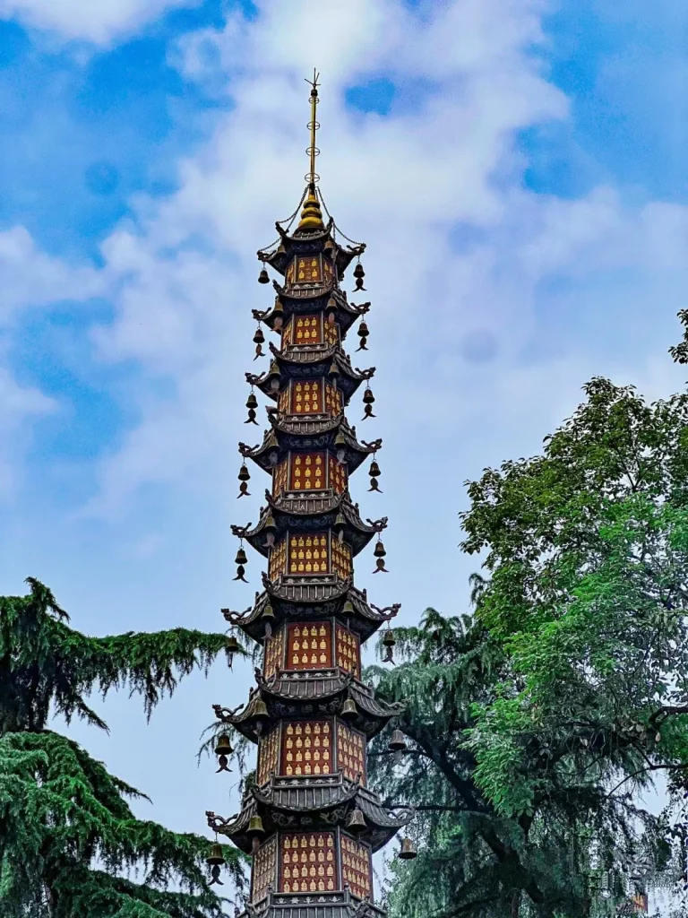 Iconic Chinese pagoda standing tall against a blue sky and surrounded by lush trees in Chengdu