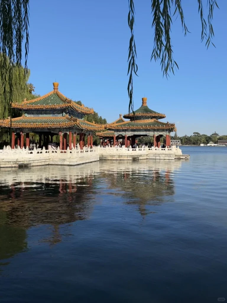 Lakeside traditional pavilions with reflections on the calm water in Beijing