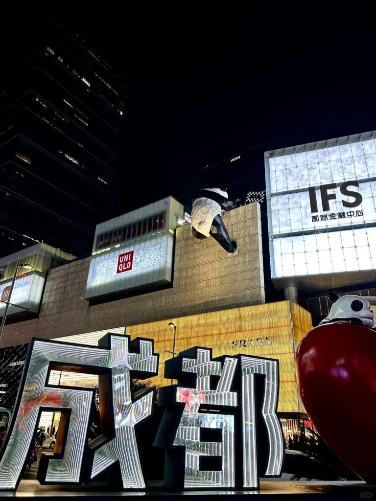 Night view of IFS building in Chengdu with a panda sculpture climbing the wall