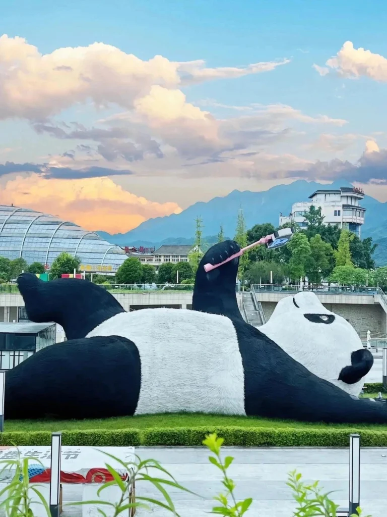Chengdu Giant Panda Sculpture A playful giant panda sculpture in Chengdu Sichuan China with a scenic mountain backdrop