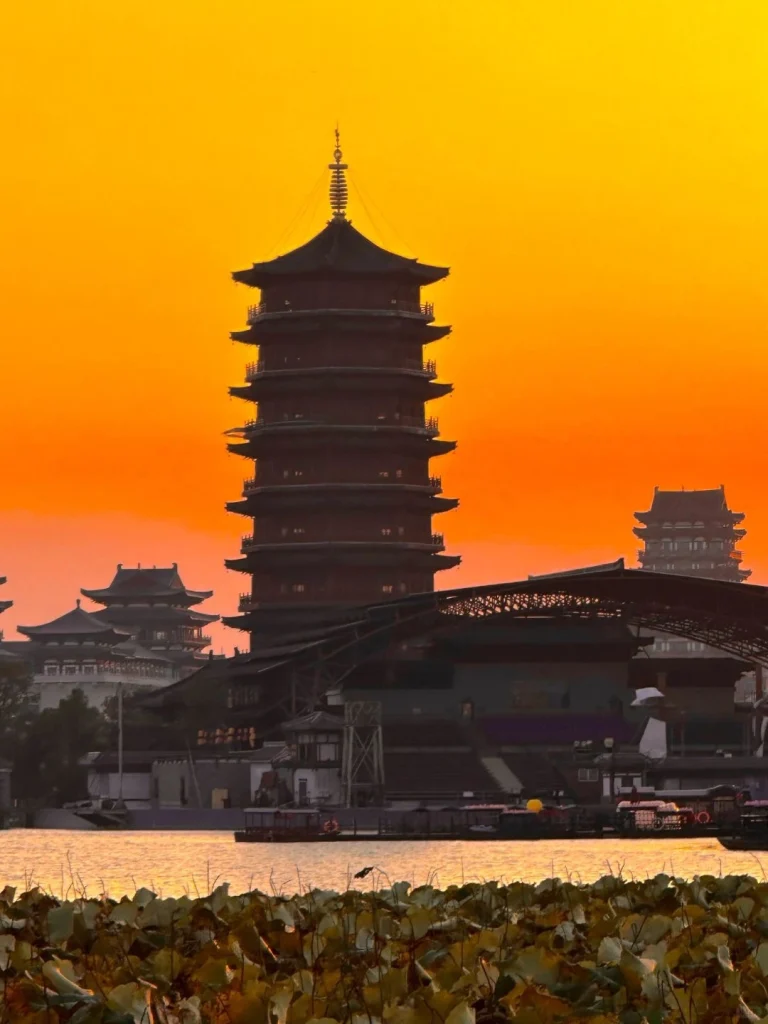 Lushan Temple Pagoda Changsha A grand multi tiered pagoda standing against a vibrant orange sunset at Lushan Temple Changsha surrounded by traditional Chinese architecture