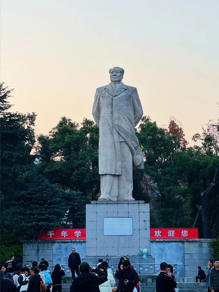Mao Zedong Statue Changsha China A grand stone statue of Mao Zedong at Orange Isle in Changsha surrounded by visitors and trees