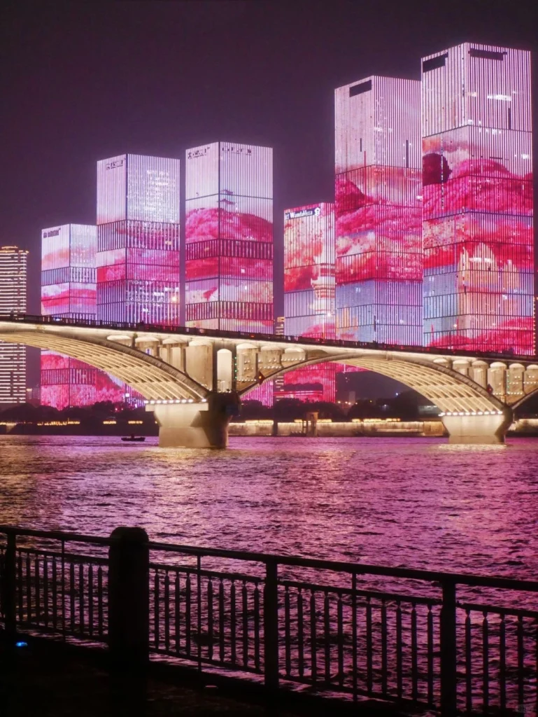 Vibrant skyline of Changsha with illuminated skyscrapers and a bridge reflecting on the Xiang River
