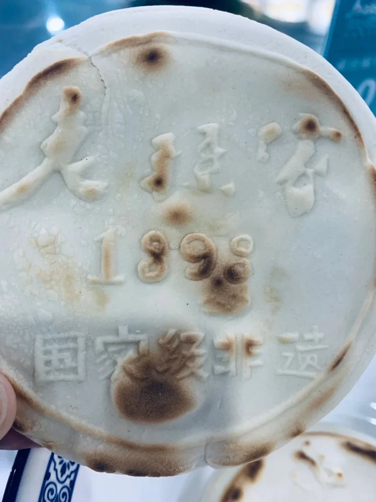 A clay dish stamped with Laosunjia Restaurants logo and the year 1898