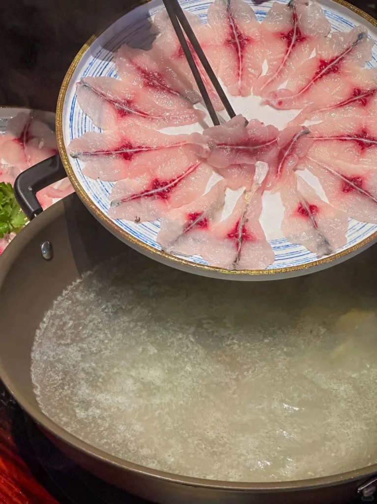 A delicious hotpot spread in Guangxi with thinly sliced meats and fresh vegetables ready for boiling