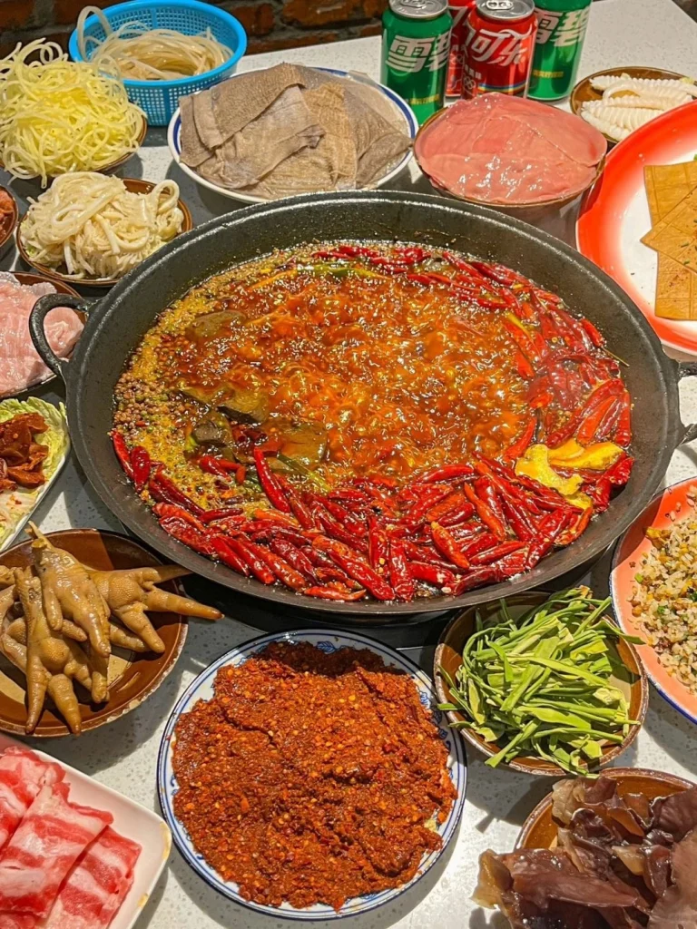 A hearty Sichuan hotpot served with a variety of meats and fresh vegetables including a spicy base