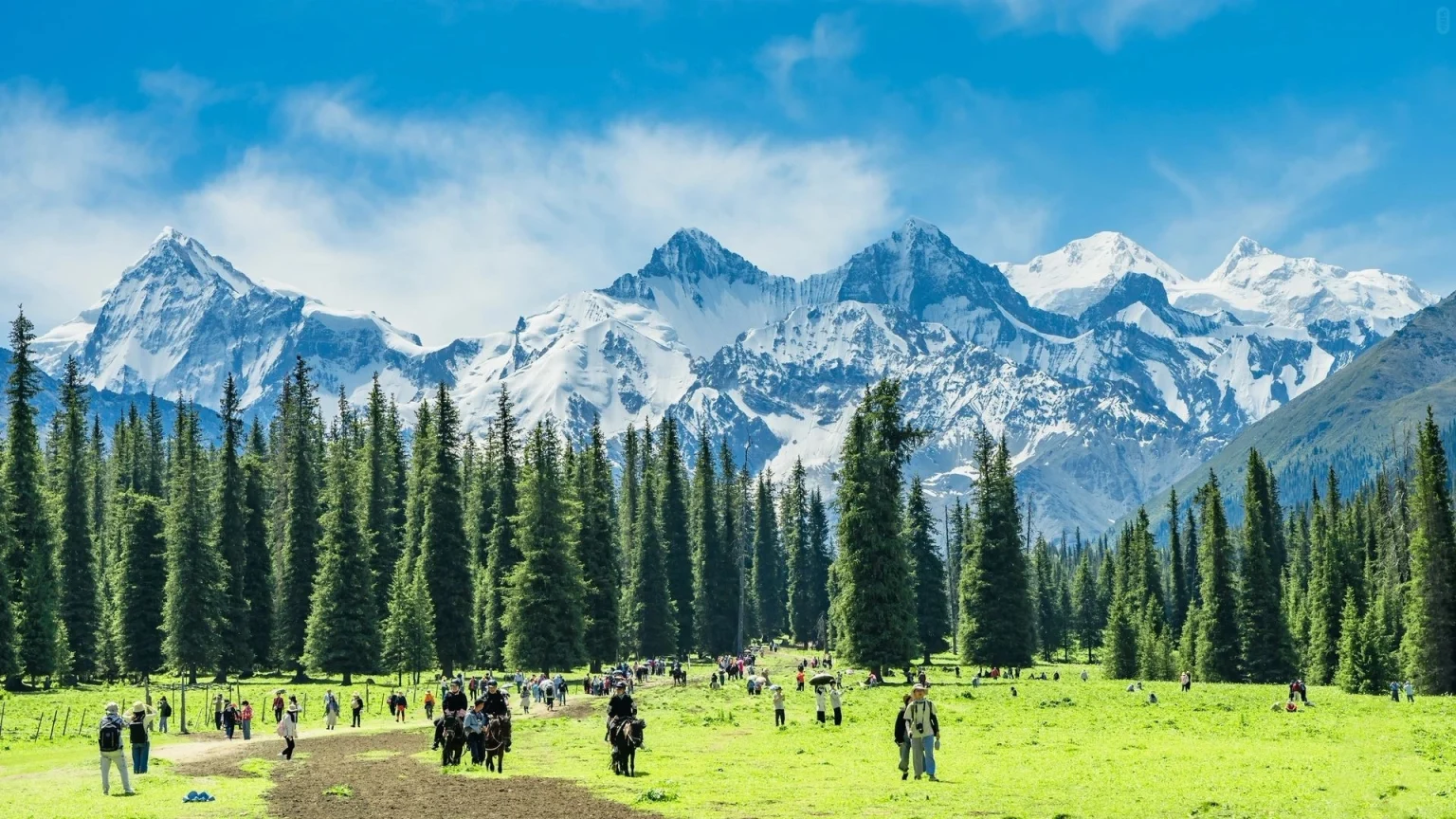 Un pintoresco paisaje montañoso en Xinjiang con exuberantes campos verdes, árboles imponentes y picos nevados bajo un cielo azul claro - Xinjiang, Costumbres étnicas de las regiones occidentales 2026 - El viaje a China - Provincias de China - Descubre la cultura y el patrimonio regional - El viaje a China Un pintoresco paisaje montañoso en Xinjiang con exuberantes campos verdes, árboles imponentes y picos nevados bajo un cielo azul claro - Xinjiang, Costumbres étnicas de las regiones occidentales 2026 - El viaje a China - Provincias de China - Descubre la cultura y el patrimonio regional - El viaje a China