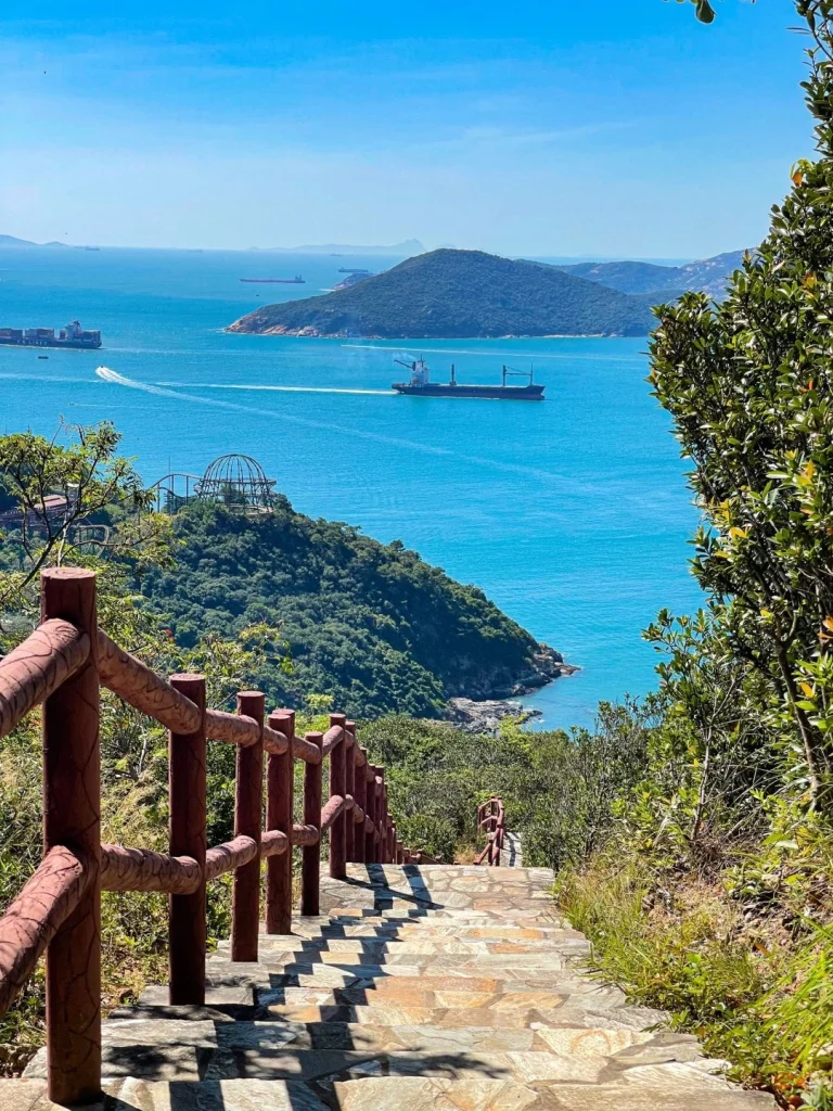 A picturesque view from a mountain trail in Hong Kong looking down towards the sea and distant islands
