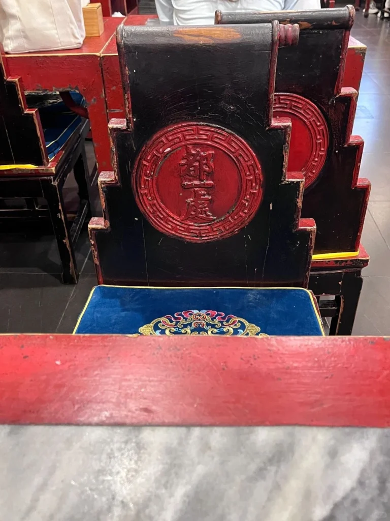 Antique wooden chairs and rich red decor inside the Du Yi Chu restaurant emphasizing its traditional Beijing restaurant ambiance
