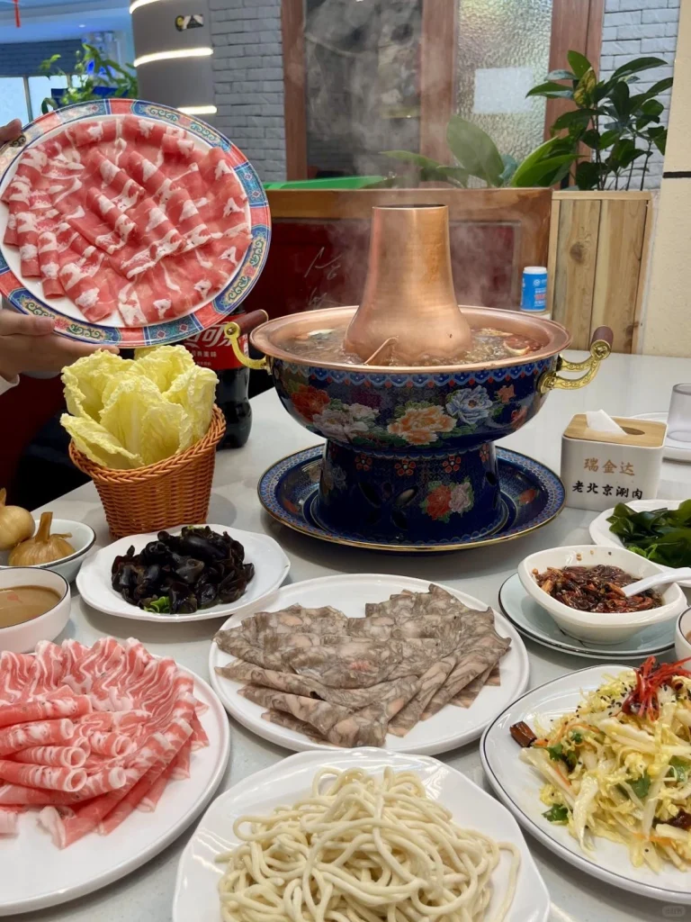 Beijing Copper Pot Hot Pot Fresh lamb and beef with a variety of vegetables served with flavorful dipping sauces around a steaming copper pot