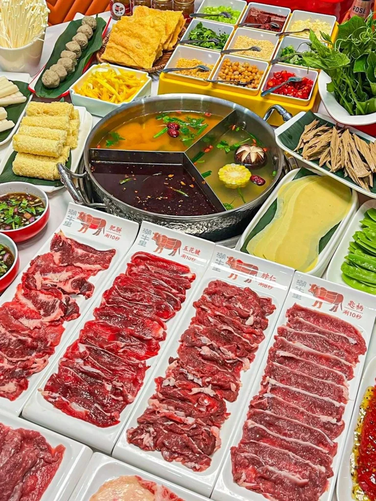 Chaozhou Beef Hotpot A selection of tender beef slices served with hotpot broth and fresh ingredients in a vibrant setting