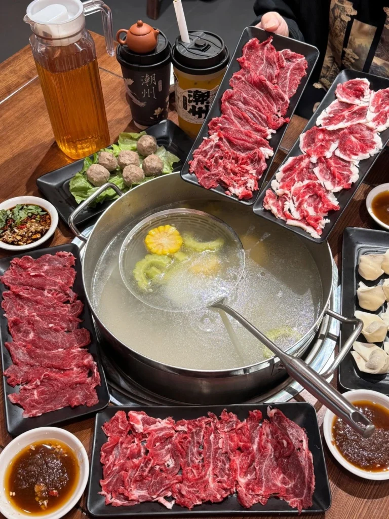 Chaozhou Beef Hotpot Delights Fresh beef vegetables and a variety of sauces set around a bubbling hotpot