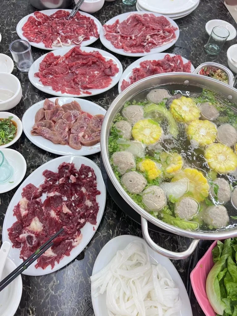 Chaozhou Beef Hotpot with Broth A sizzling pot of beef mushrooms and corn with dipping sauces and fresh vegetables
