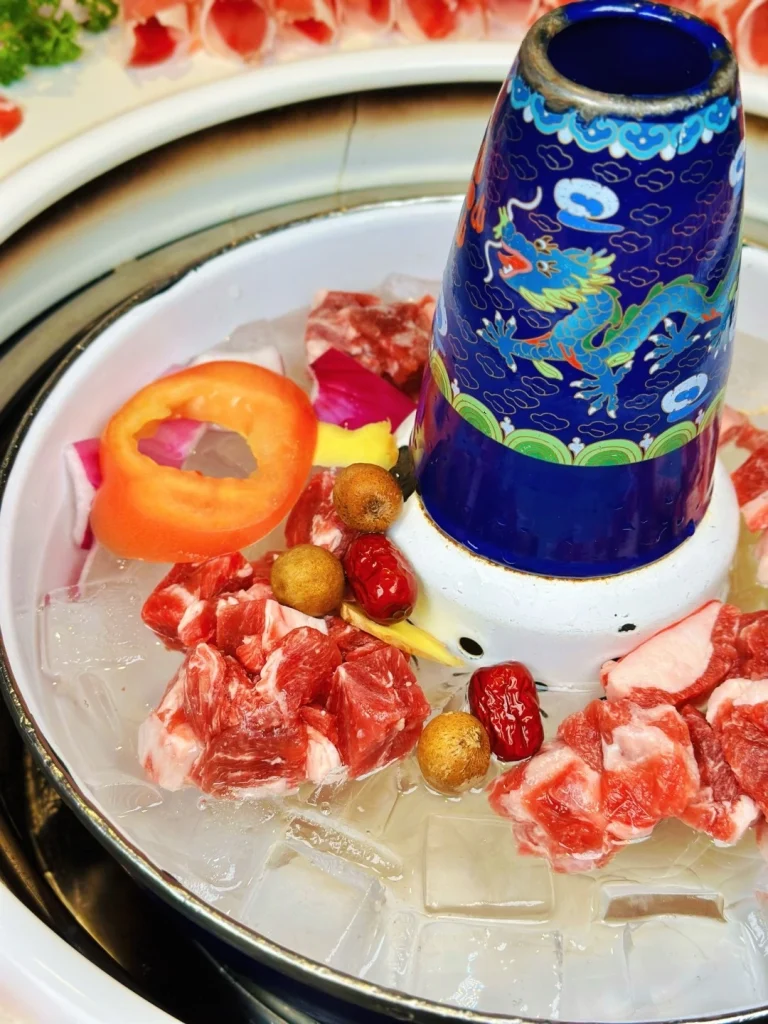 Close up of Ice Boiled Lamb Pot Mutton chunks on ice in a blue patterned pot