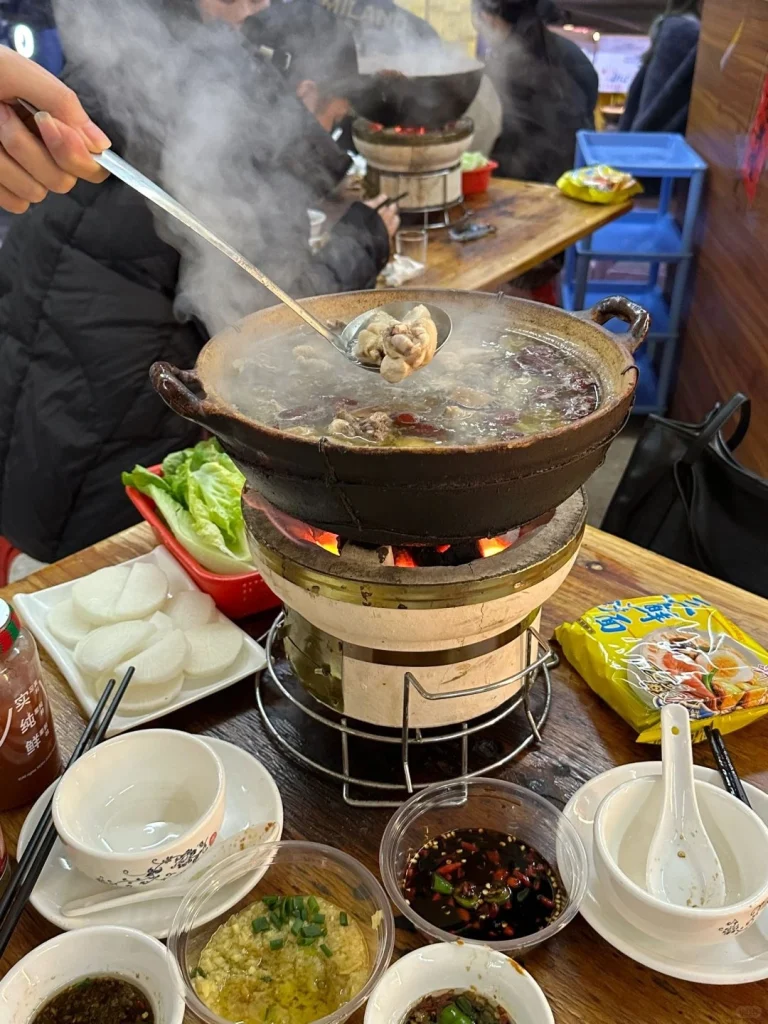 Close up of a flavorful hotpot broth filled with meat and vegetables perfect for a Guangdong family meal