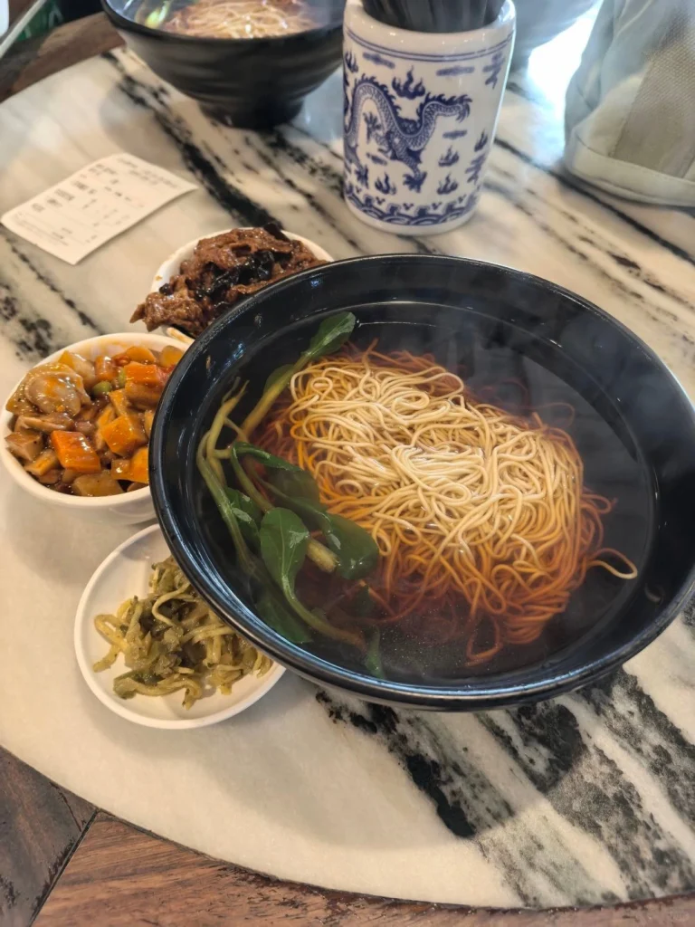 Close up of a traditional vegetarian dish served at Gong Delin restaurant with an array of vegetables and noodles