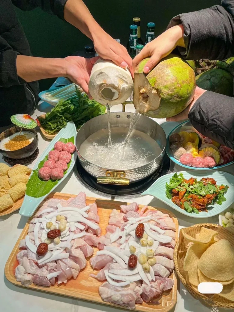 Creating Coconut Chicken Hot Pot Two people pouring coconut water together