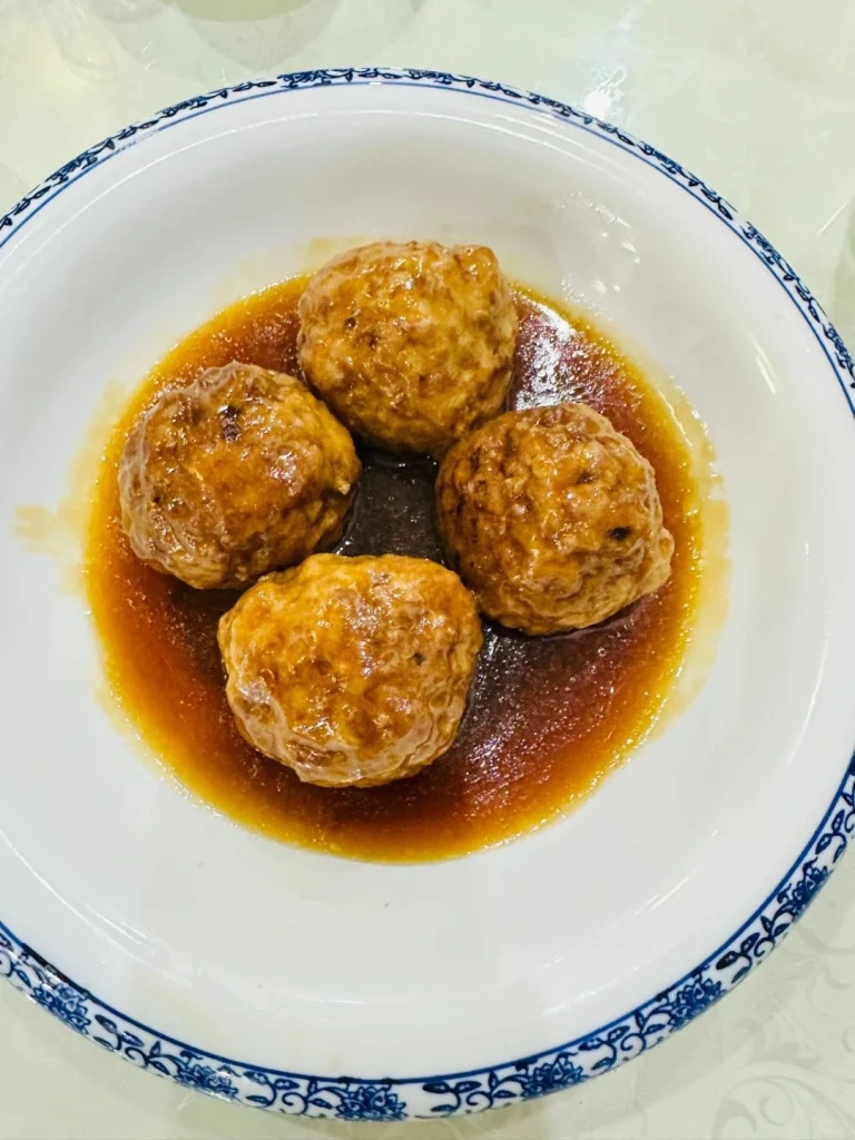 Delicious meatballs in rich sauce served at Jufengde showcasing traditional Chinese cuisine