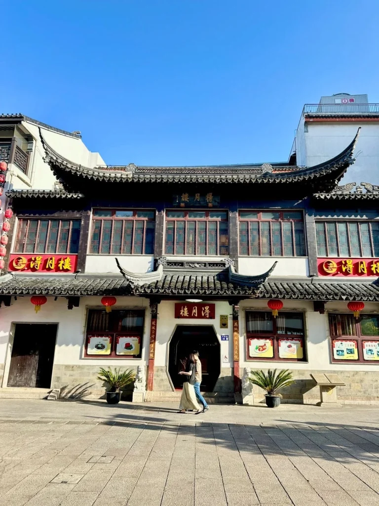 Deyue Lou restaurant exterior at night Elegant building with glowing lights and signs located in Suzhous historical district