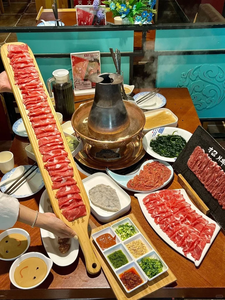 Dong Lai Shun copper pot hot pot A colorful display of fresh ingredients for a traditional Chinese hot pot meal including thinly sliced meat and vegetables