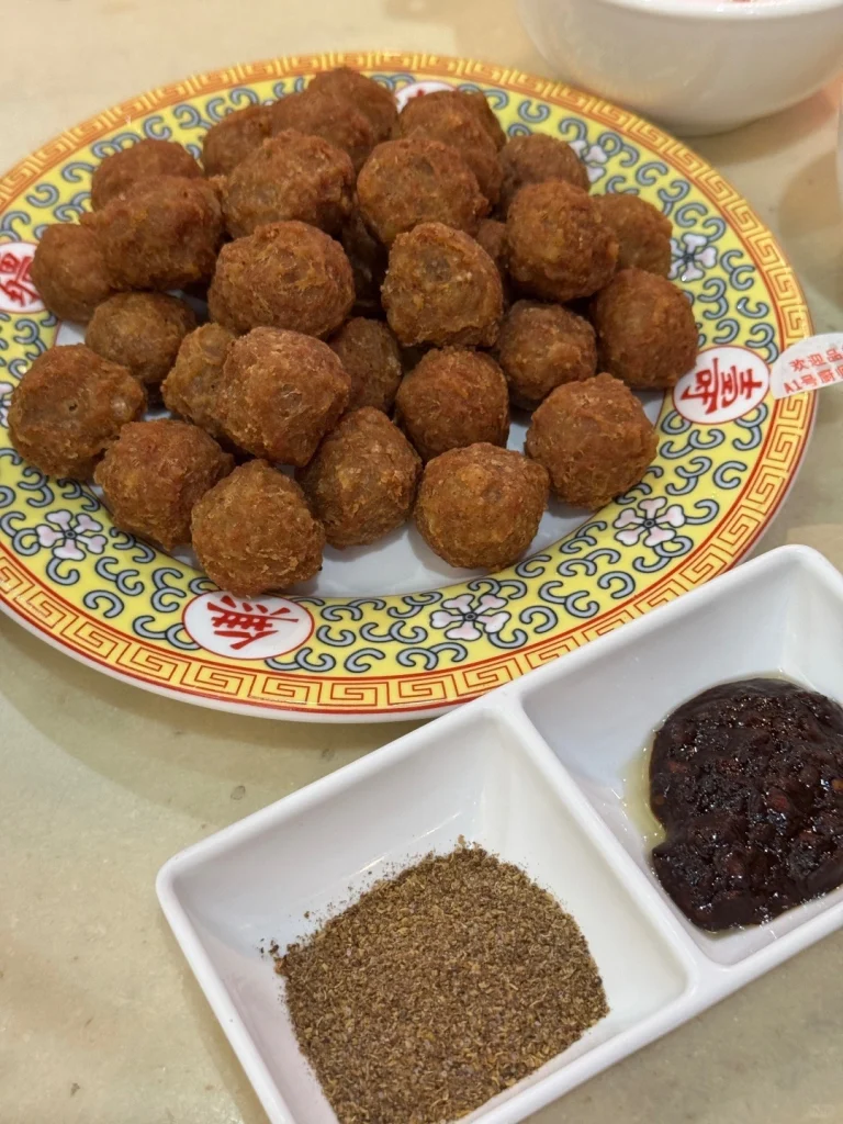 Fried meatballs at Shaguoju restaurant in Beijing Delicious fried meatballs served with seasonings and dipping sauces at Shaguoju restaurant in Beijing