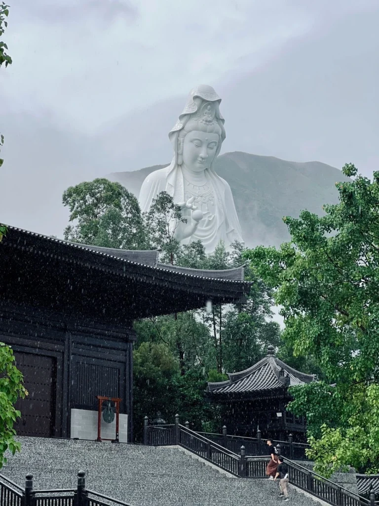 Giant Guanyin statue at Tsz Shan Monastery Majestic view of the large Guanyin statue overlooking Tsz Shan Monastery and surrounding lush greenery in Hong Kong