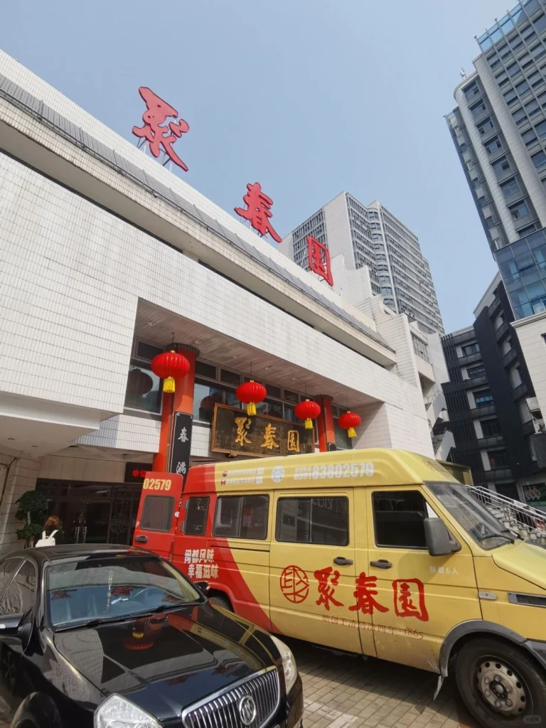 Juchun Garden restaurant exterior A vibrant exterior shot of Juchun Garden restaurant in Fuzhou with its bright signage and the yellow food delivery van parked outside