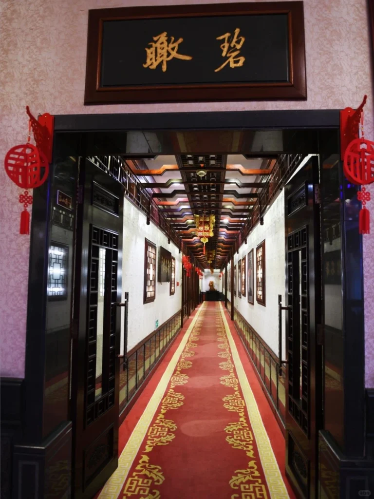 Long corridor inside Lou Wai Lou with red lantern decorations and ornate wall art