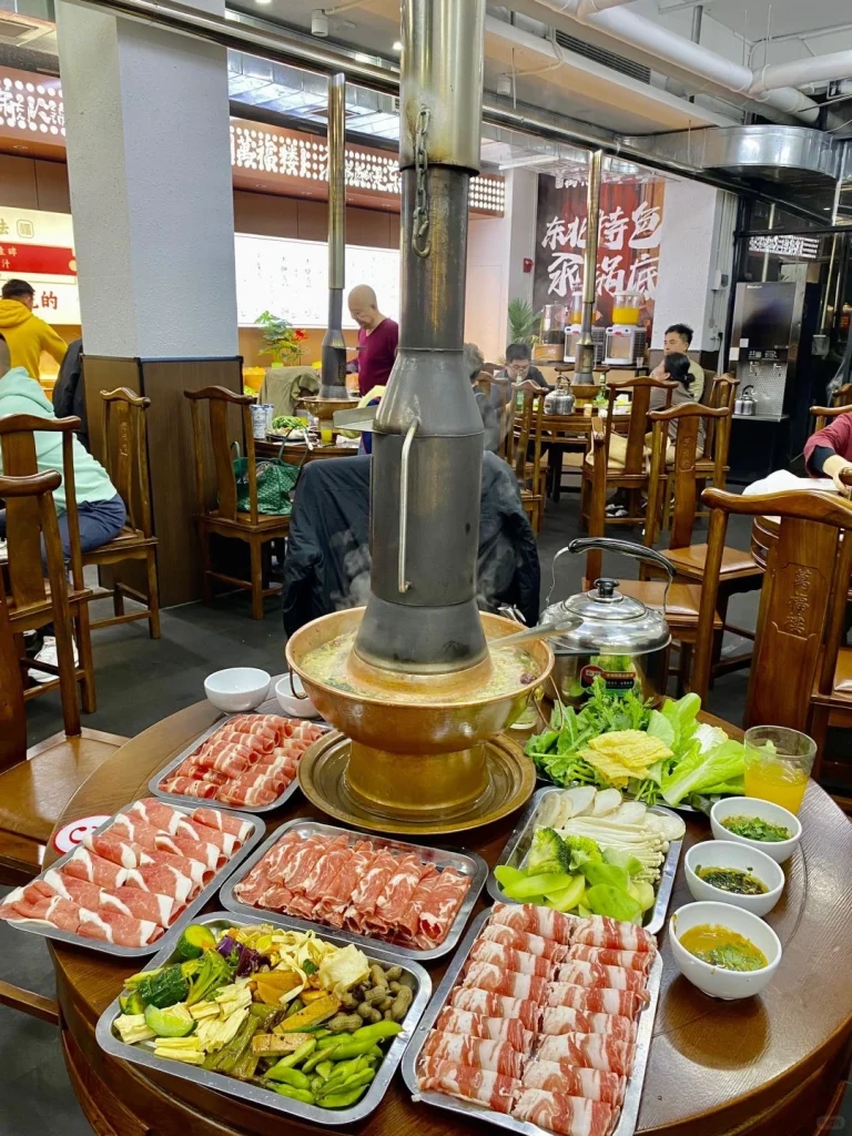 Northeast China Hot Pot Copper pot with various meats and veggies on the table