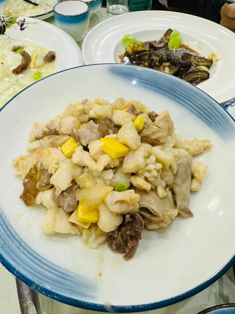 Plate of flavorful Chinese dish with diced chicken vegetables and sauce at Jufengde restaurant