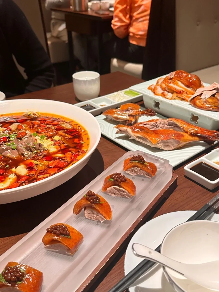 Roast duck dishes served in a Beijing restaurant featuring delicious duck and side dishes with chili and herbs