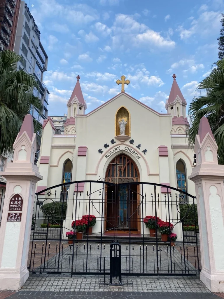 Rosary Church with a pink and white exterior and clear blue skies above in Hong Kong