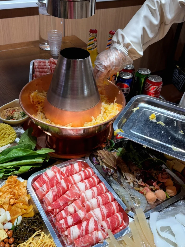 Setting up Northeast Hot Pot Adding ingredients around the large copper pot