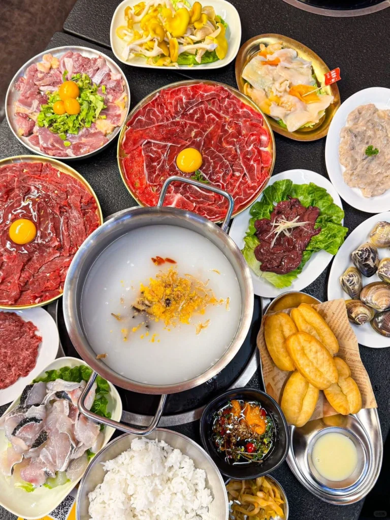 Shunde congee based hotpot with various ingredients like meat vegetables and mushrooms in a pot