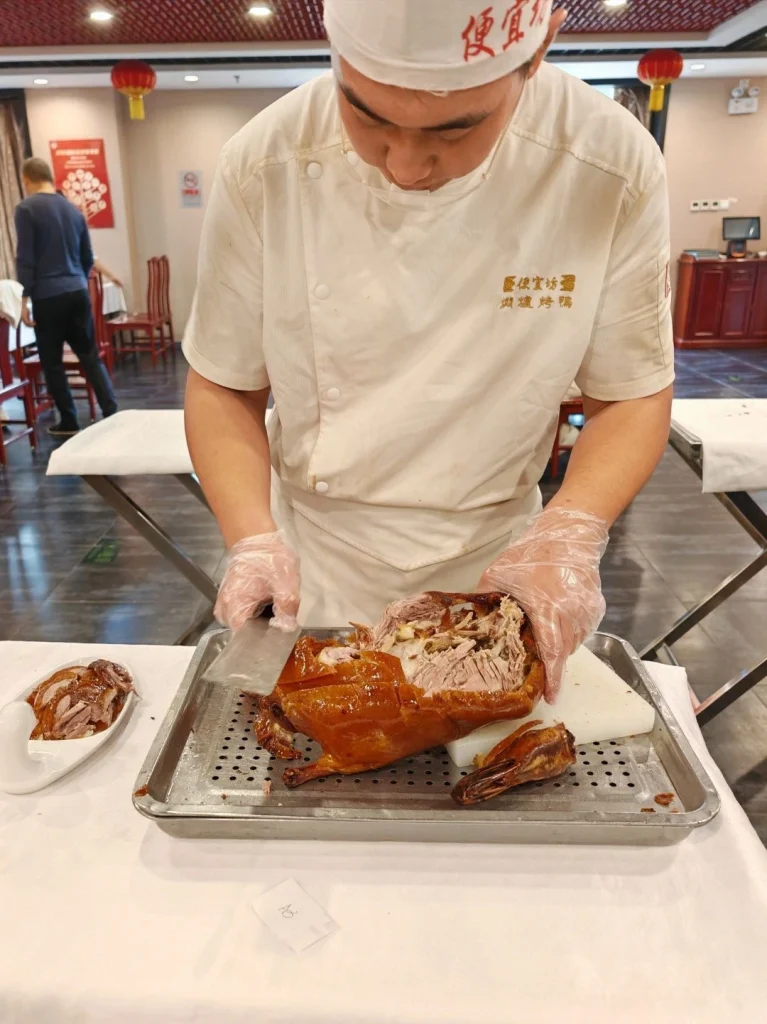 Tender roast duck served with sauces highlighting the crispy skin and tender meat at a Beijing restaurant